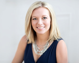 Headshot of attorney Ryan Kelly in a blue dress against a white wall
